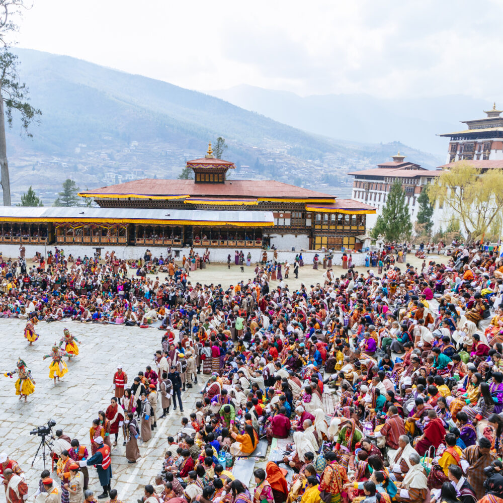 Vibrant masked dancers performing at a Bhutanese festival